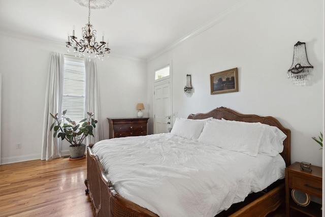 bedroom with light wood-style floors, ornamental molding, baseboards, and a notable chandelier