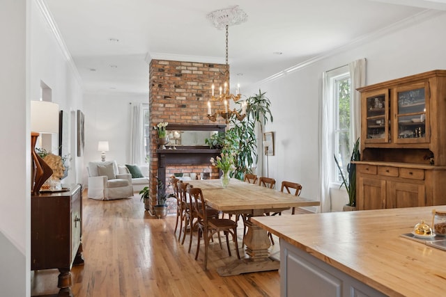dining area featuring light wood finished floors, ornamental molding, and an inviting chandelier