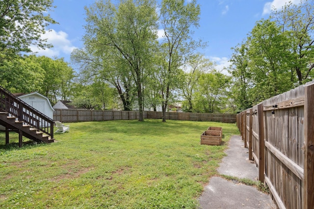 view of yard featuring a fenced backyard, a storage unit, and an outdoor structure