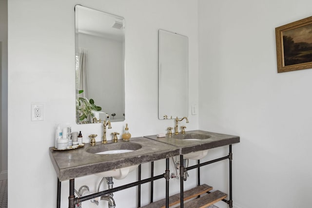 bathroom featuring baseboards and a sink
