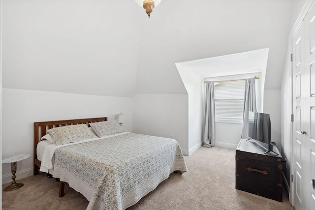 bedroom featuring baseboards, lofted ceiling, and light colored carpet