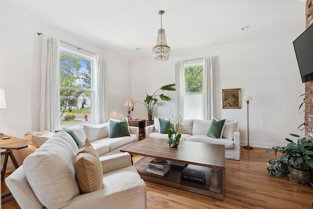 living room with a wealth of natural light, ornamental molding, wood finished floors, and baseboards