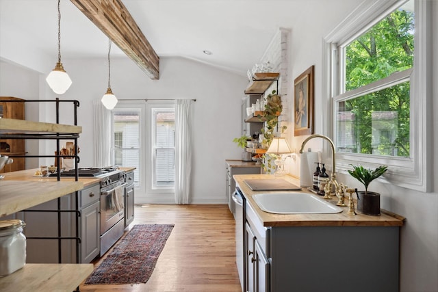 kitchen with stainless steel appliances, a sink, light wood-type flooring, vaulted ceiling with beams, and gray cabinets