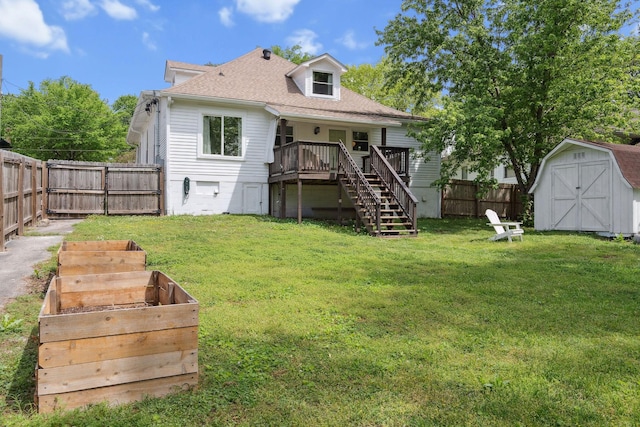 back of property featuring a storage unit, a fenced backyard, a lawn, stairway, and a deck