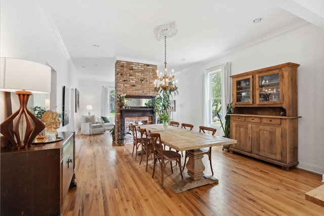 dining space with crown molding and light wood finished floors