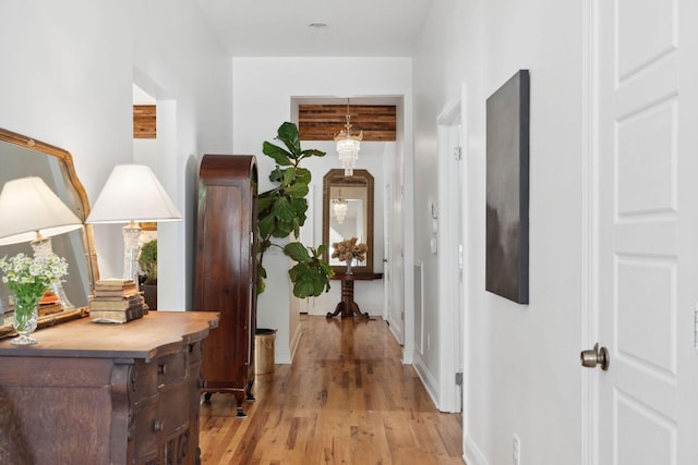 corridor featuring baseboards and light wood-style flooring