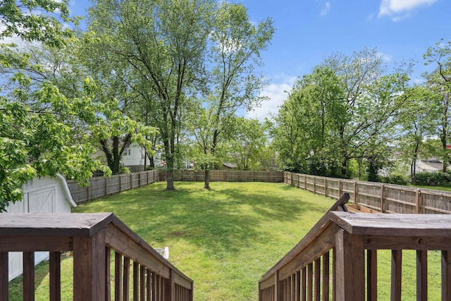 view of yard featuring a fenced backyard, an outdoor structure, and a storage shed