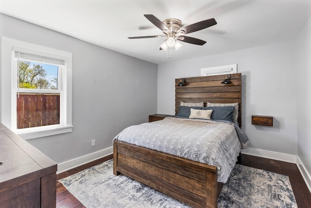 bedroom with baseboards, ceiling fan, and dark wood-style floors