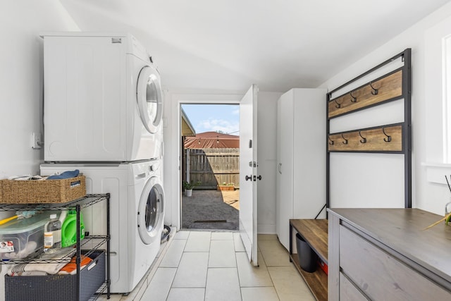 clothes washing area with stacked washer and clothes dryer, laundry area, and light tile patterned floors