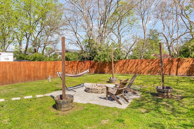 view of yard featuring a fire pit, a patio, and a fenced backyard