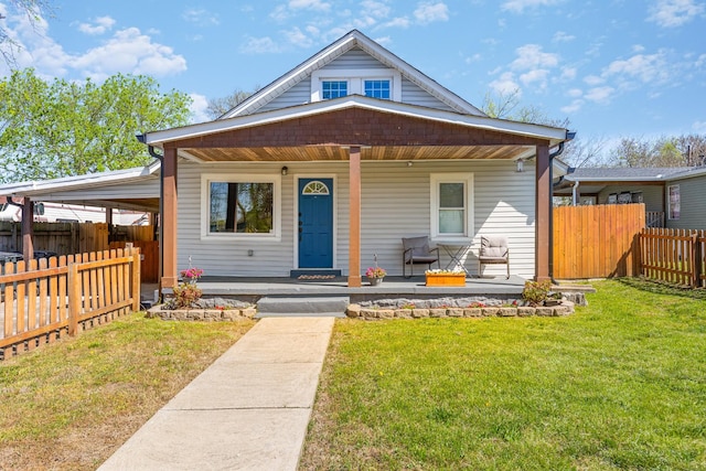 bungalow with a porch, a front lawn, and fence
