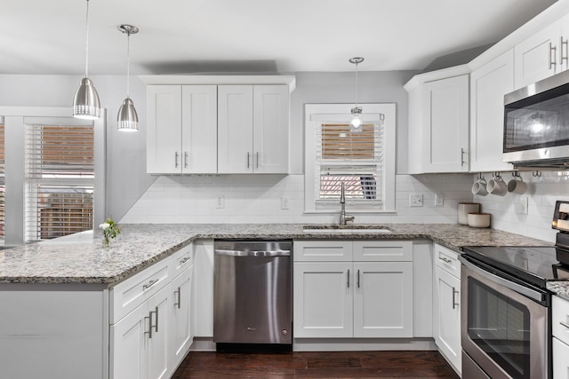 kitchen featuring decorative backsplash, appliances with stainless steel finishes, a sink, and white cabinets