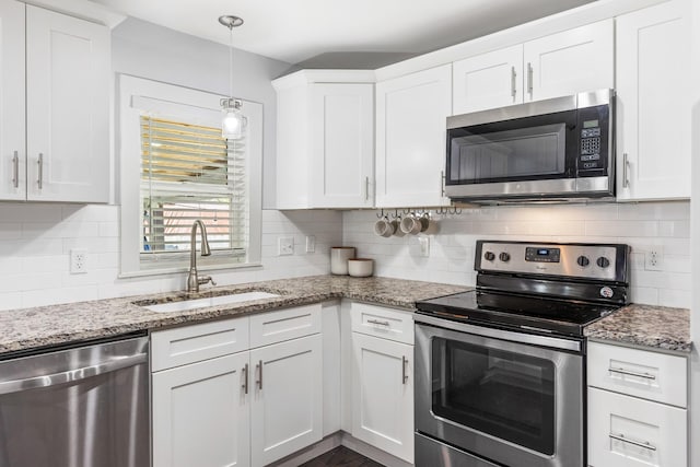 kitchen featuring white cabinets, stainless steel appliances, a sink, and backsplash