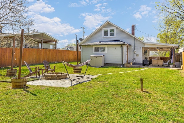 rear view of house featuring fence, ceiling fan, a lawn, and a patio area