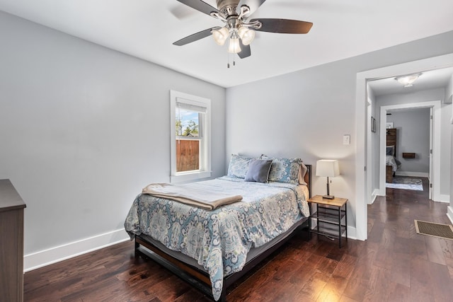 bedroom with wood finished floors, visible vents, a ceiling fan, and baseboards