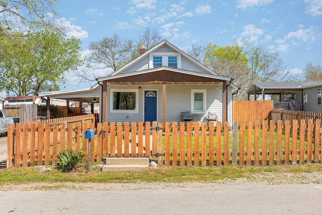 bungalow featuring a chimney, a fenced front yard, and covered porch