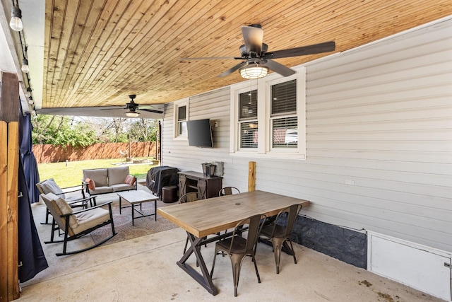 view of patio / terrace featuring a fenced backyard, an outdoor living space, a ceiling fan, and outdoor dining space