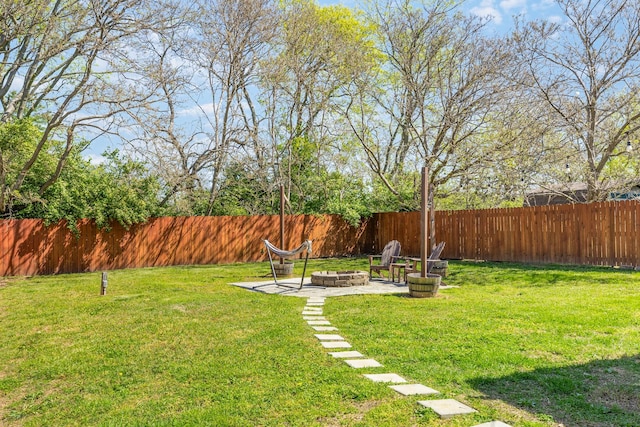 view of yard featuring a fire pit, a patio, and a fenced backyard