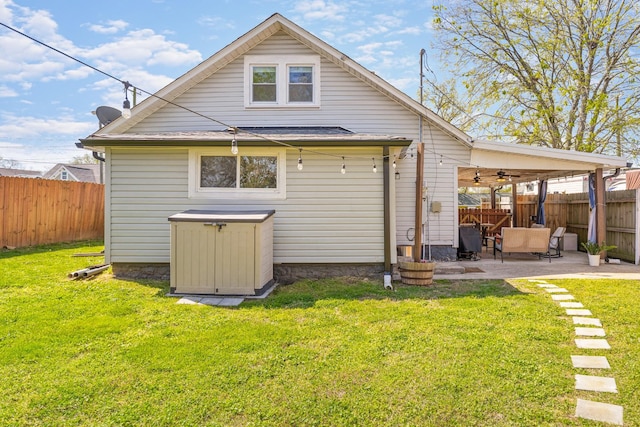 back of house with a patio area, a lawn, a fenced backyard, and ceiling fan
