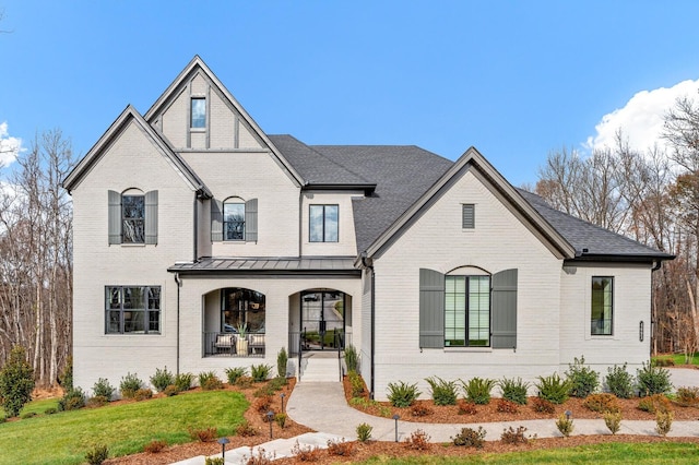 7247 Murrel Dr, Franklin, TN 37064 - french country home with brick siding, a porch, a front lawn, and a standing seam roof