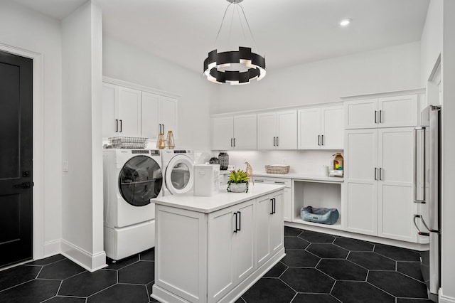 7247 Murrel Dr, Franklin, TN 37064 - laundry area with a chandelier, cabinet space, dark tile patterned flooring, and washer and clothes dryer