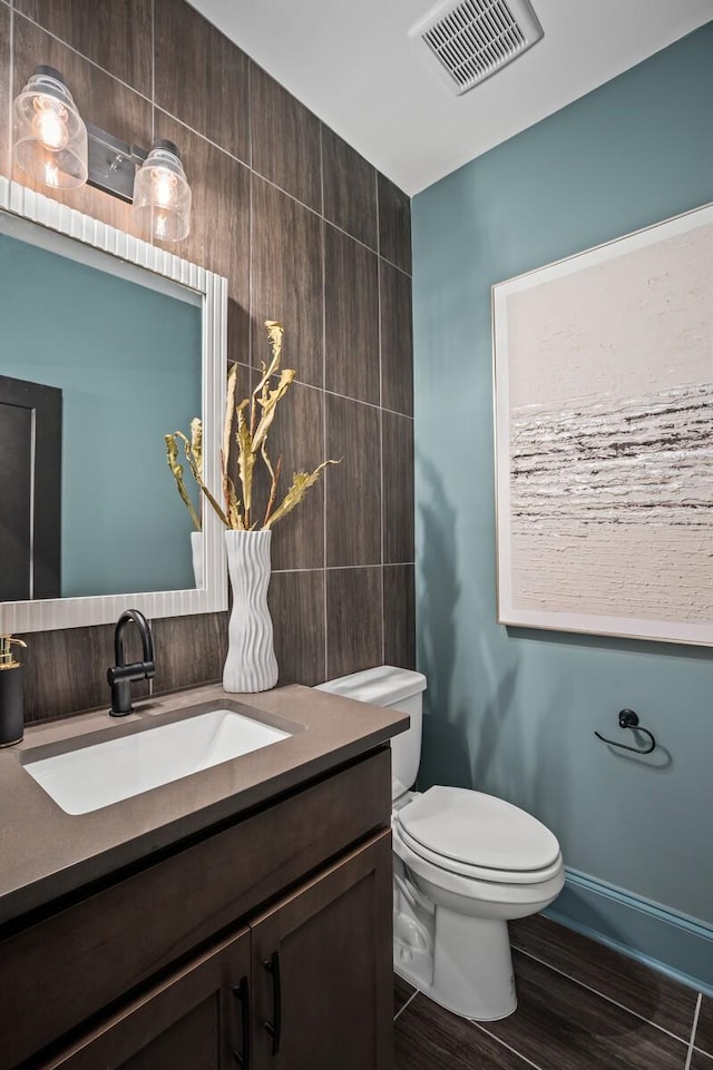 7247 Murrel Dr, Franklin, TN 37064 - half bathroom with toilet, tile walls, visible vents, wood finished floors, and vanity