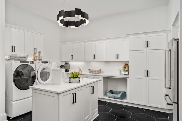 7247 Murrel Dr, Franklin, TN 37064 - washroom featuring dark tile patterned flooring, washer and clothes dryer, and cabinet space