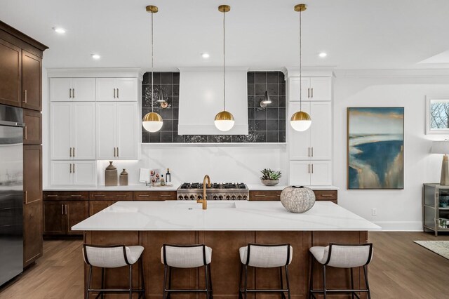 7247 Murrel Dr, Franklin, TN 37064 - kitchen with decorative backsplash, wood finished floors, a breakfast bar, and stainless steel built in fridge
