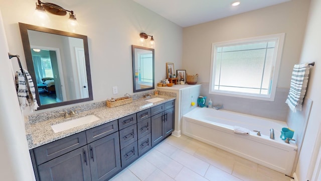 full bath featuring a bath, a wealth of natural light, and a sink