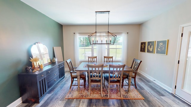 dining space featuring baseboards, dark wood-style floors, and an inviting chandelier