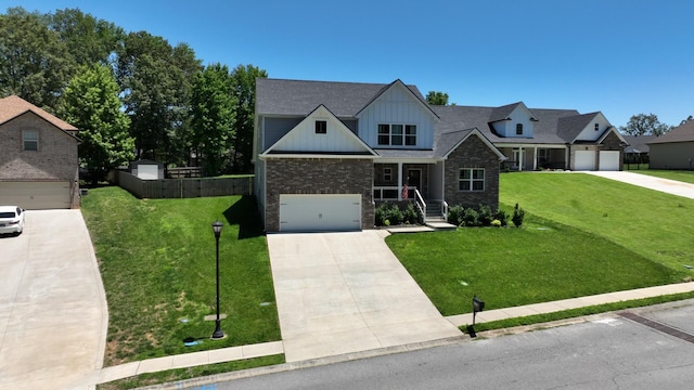 view of front of home with a front lawn, driveway, fence, a garage, and board and batten siding