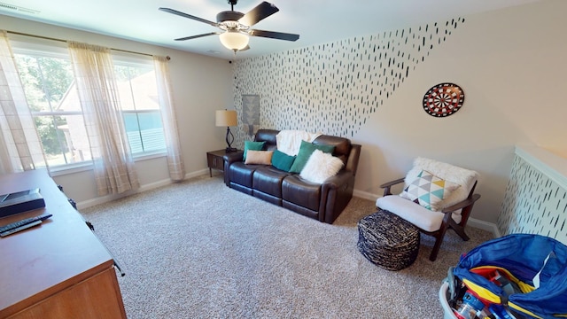 carpeted living area with visible vents, a ceiling fan, baseboards, and a healthy amount of sunlight