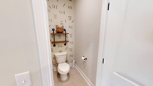 bathroom with toilet, tile patterned flooring, and baseboards