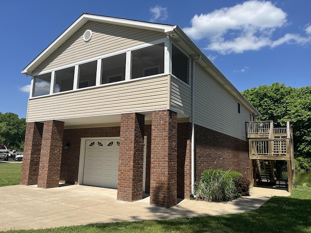 1473 Chapmansboro Rd, Chapmansboro, TN 37035 - view of property exterior featuring a garage, a sunroom, concrete driveway, stairway, and brick siding