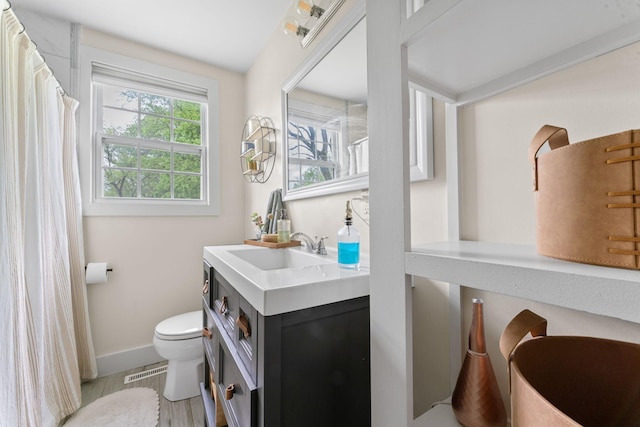 bathroom featuring vanity, baseboards, toilet, a shower with shower curtain, and visible vents