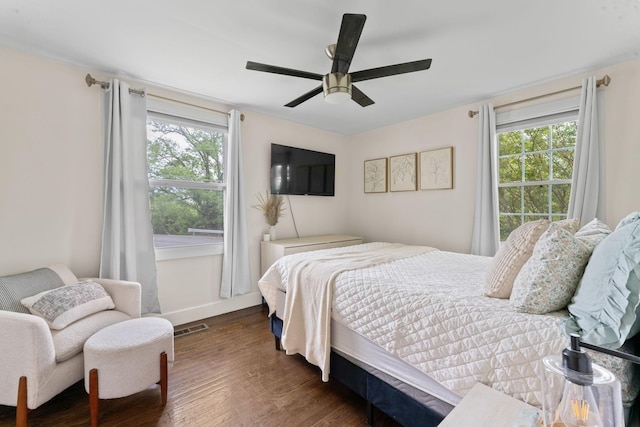 bedroom featuring ceiling fan, baseboards, wood finished floors, and visible vents