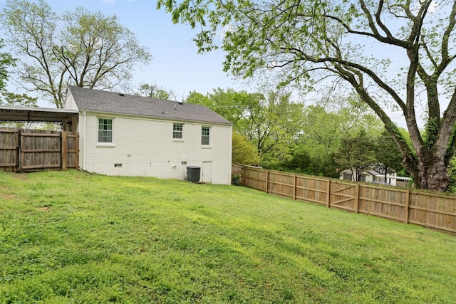 rear view of house with central air condition unit, a lawn, crawl space, and a fenced backyard