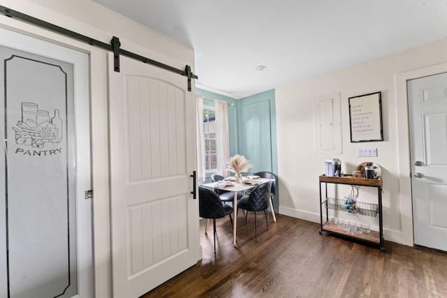 dining area featuring a barn door, baseboards, and dark wood-type flooring
