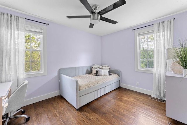bedroom with baseboards, visible vents, and multiple windows