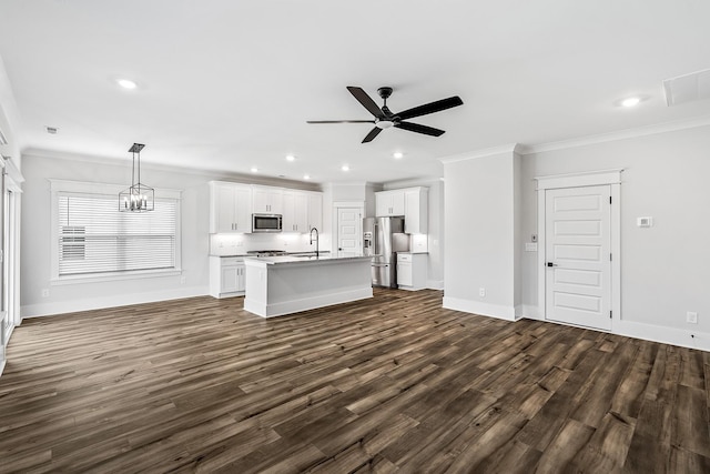 unfurnished living room with a sink, baseboards, dark wood-style flooring, ornamental molding, and ceiling fan with notable chandelier