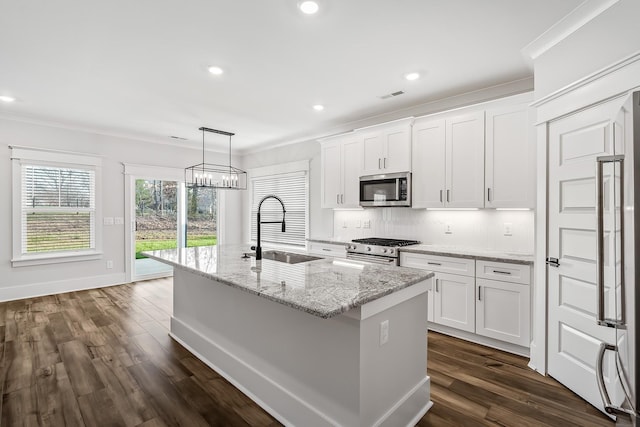 kitchen with a kitchen island with sink, appliances with stainless steel finishes, white cabinets, a sink, and visible vents