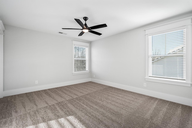 unfurnished room featuring carpet, visible vents, ceiling fan, and baseboards