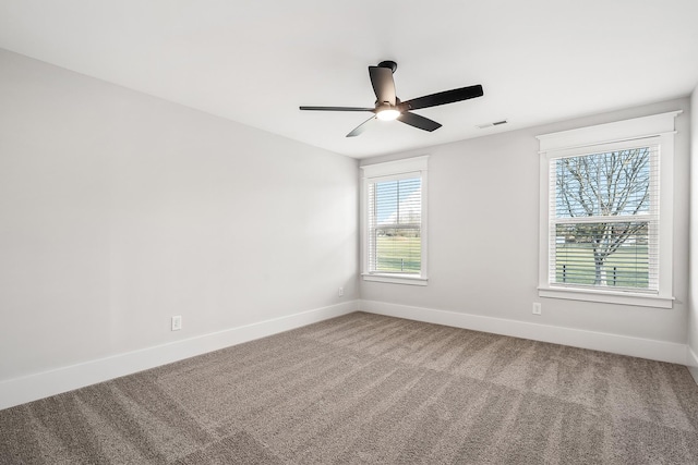 carpeted empty room with a ceiling fan, visible vents, and baseboards