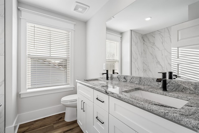 bathroom with toilet, a sink, visible vents, and baseboards