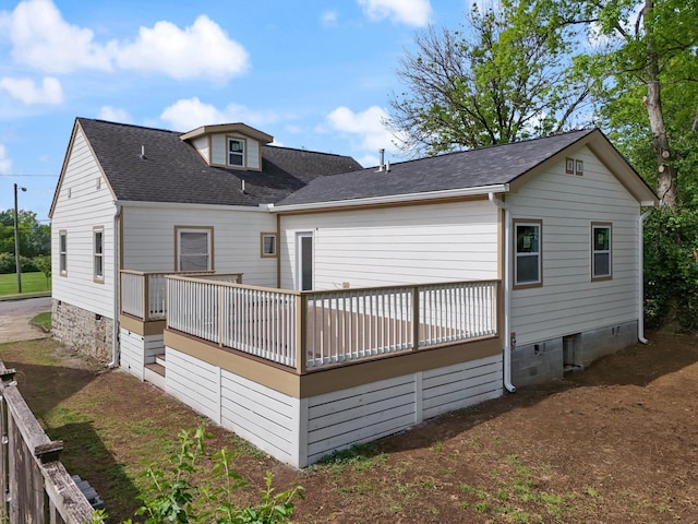 rear view of property featuring a wooden deck and a shingled roof