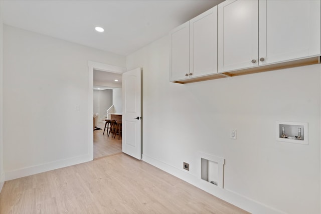clothes washing area featuring hookup for an electric dryer, cabinet space, baseboards, hookup for a washing machine, and light wood-style flooring