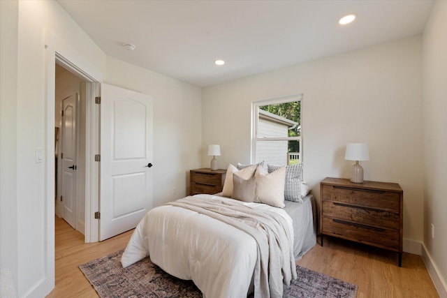 bedroom with recessed lighting, light wood finished floors, and baseboards