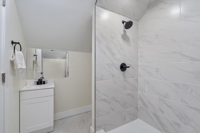 bathroom with vanity, baseboards, tiled shower, and marble finish floor
