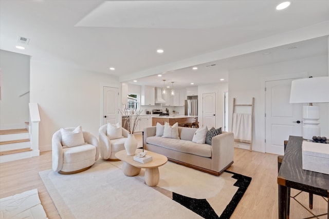 living area with recessed lighting, light wood finished floors, stairs, and visible vents