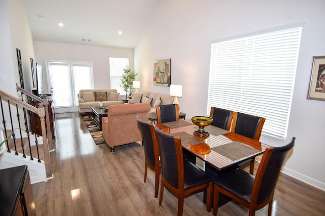 dining space featuring recessed lighting, stairway, vaulted ceiling, wood finished floors, and baseboards